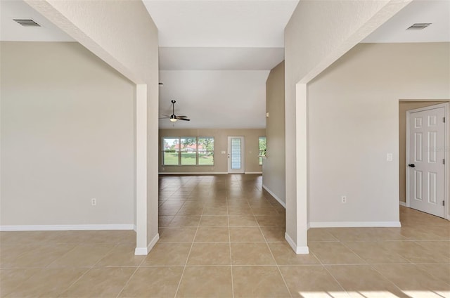 hallway featuring vaulted ceiling and light tile patterned floors