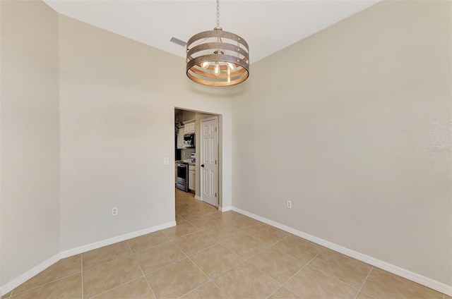 unfurnished room featuring light tile patterned floors and a notable chandelier