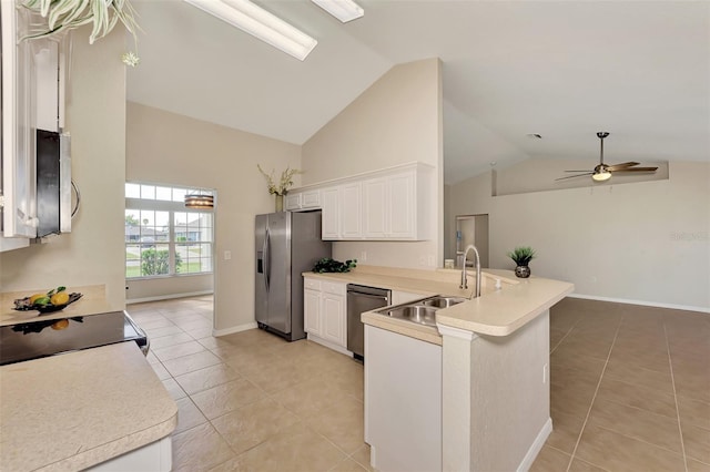 kitchen featuring sink, appliances with stainless steel finishes, white cabinetry, light tile patterned flooring, and kitchen peninsula