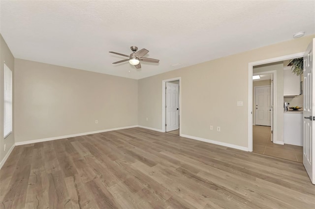 spare room featuring ceiling fan, a textured ceiling, and light hardwood / wood-style floors