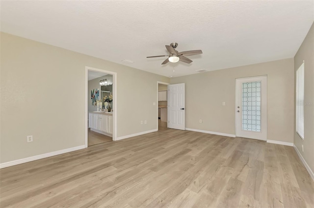 empty room featuring ceiling fan, light hardwood / wood-style floors, and a textured ceiling