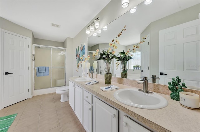 bathroom with vanity, toilet, a shower with door, and tile patterned flooring