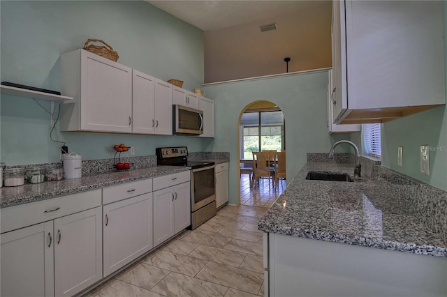 kitchen with white cabinetry, sink, stainless steel appliances, and stone countertops