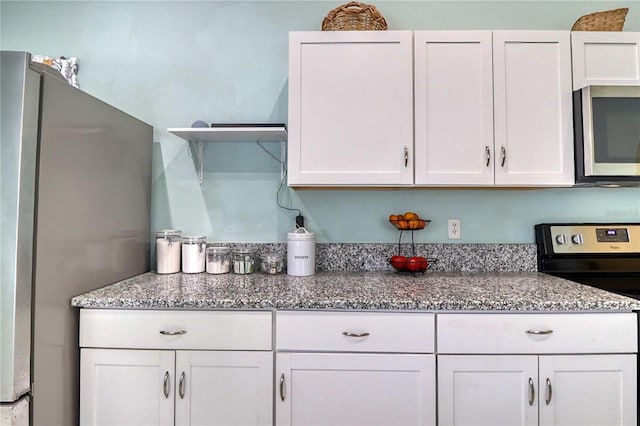 kitchen with white cabinetry, light stone countertops, and stainless steel appliances