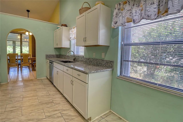 kitchen with white cabinetry, stainless steel dishwasher, stone countertops, and sink