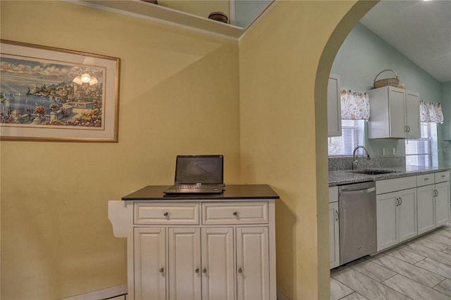 kitchen featuring lofted ceiling, dishwasher, sink, and white cabinets