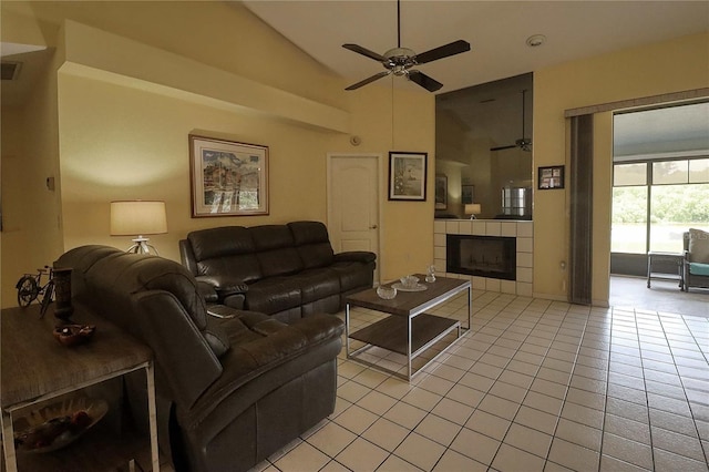 living room with a tiled fireplace, light tile patterned flooring, high vaulted ceiling, and ceiling fan