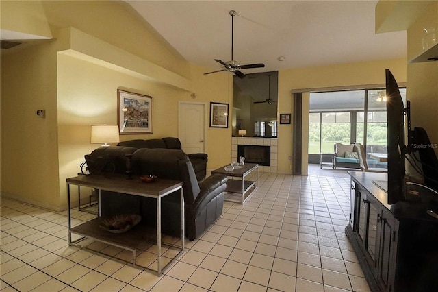 tiled living room with ceiling fan, a fireplace, and vaulted ceiling