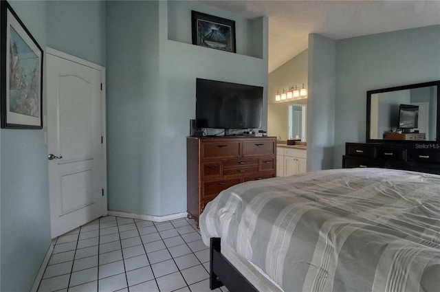 bedroom featuring connected bathroom, vaulted ceiling, and light tile patterned floors