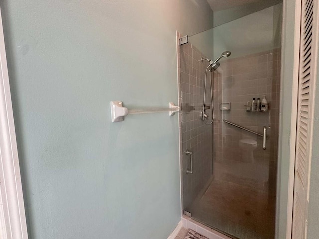 bathroom with toilet and a shower with door