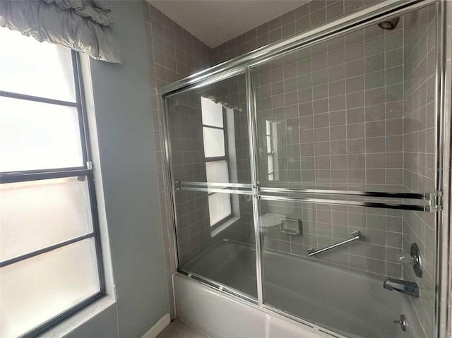 bathroom with bath / shower combo with glass door