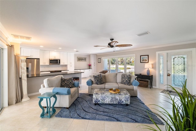 living area with light tile patterned flooring, visible vents, and ornamental molding