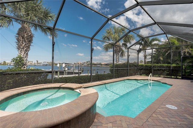 view of swimming pool featuring a pool with connected hot tub, a lanai, a water view, and a patio