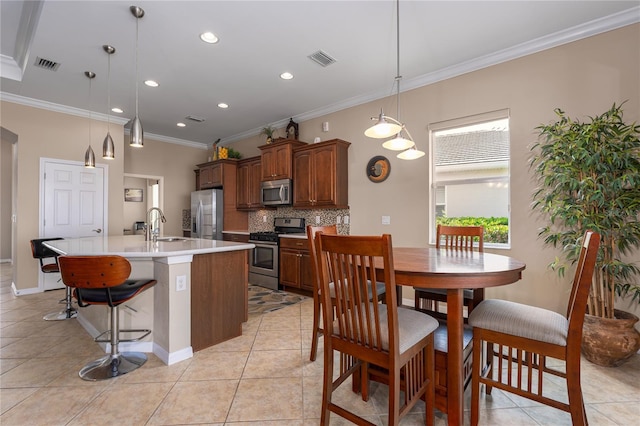 kitchen featuring stainless steel appliances, a center island with sink, backsplash, and visible vents