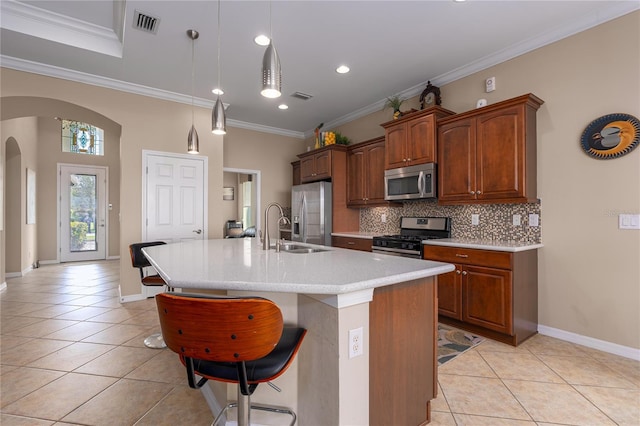 kitchen featuring arched walkways, stainless steel appliances, light tile patterned floors, and a sink