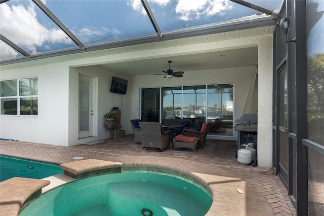 view of swimming pool featuring a ceiling fan, glass enclosure, grilling area, a patio area, and a pool with connected hot tub