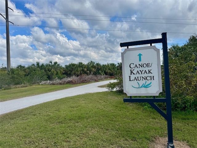 view of community with driveway and a lawn