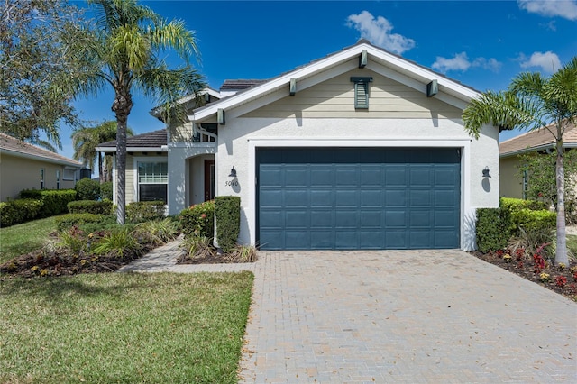 ranch-style house with an attached garage, a front lawn, decorative driveway, and stucco siding