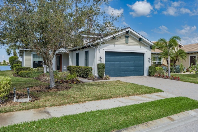 ranch-style house with a garage, stucco siding, concrete driveway, and a front yard