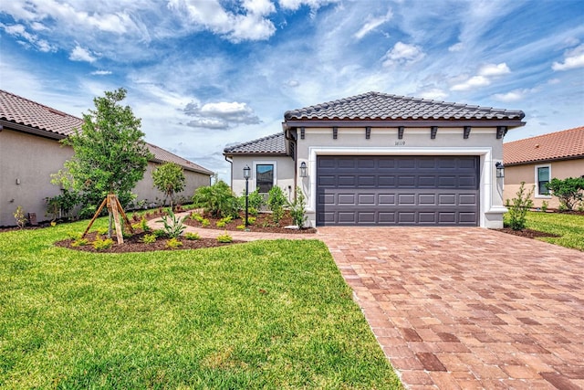 mediterranean / spanish-style home featuring a garage and a front lawn