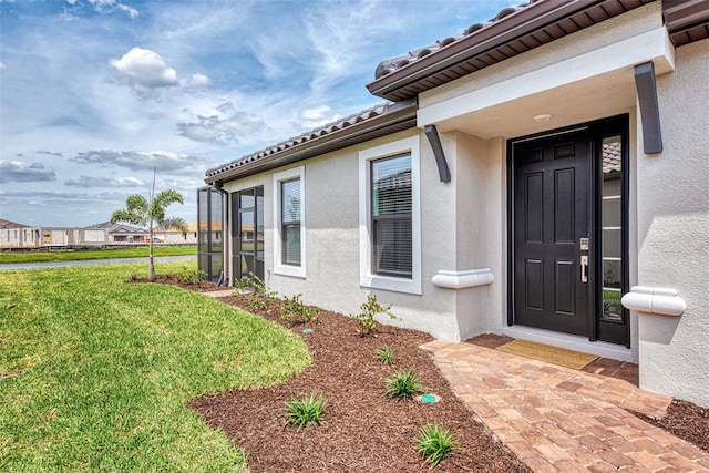 entrance to property featuring a yard