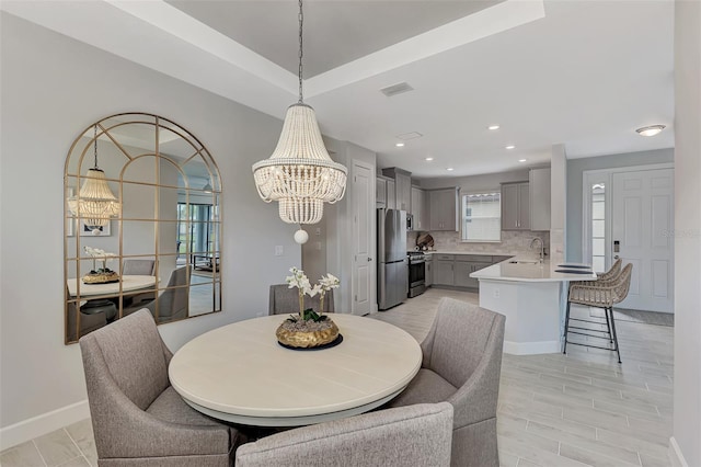 dining room featuring sink and a chandelier