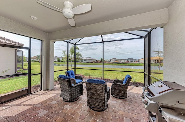 sunroom / solarium with a water view and ceiling fan