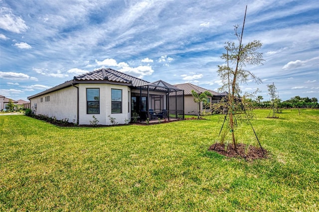 back of house with a lawn and glass enclosure