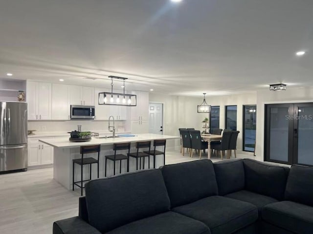 living room with sink and light hardwood / wood-style flooring