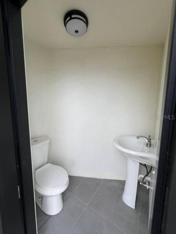 bathroom featuring toilet and tile patterned flooring