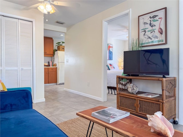 living room with ceiling fan and light tile patterned flooring