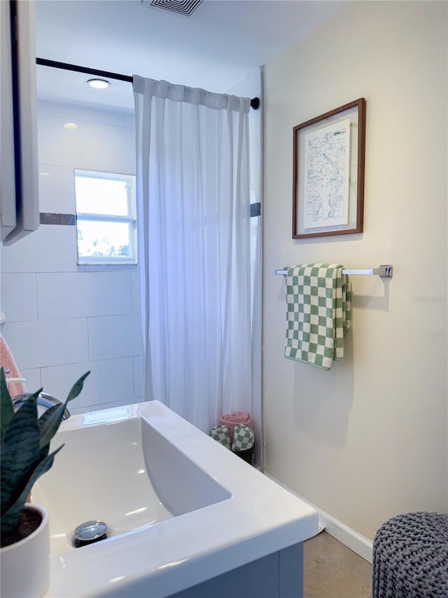 bathroom with walk in shower and vanity