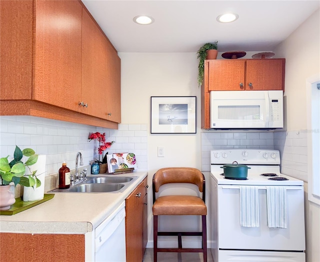 kitchen with sink, white appliances, and backsplash