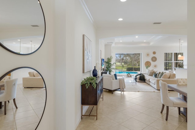 interior space featuring ornamental molding, light tile patterned flooring, and a tray ceiling