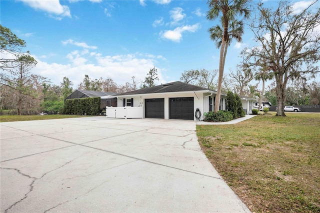 view of property exterior with a garage, a lanai, and a yard