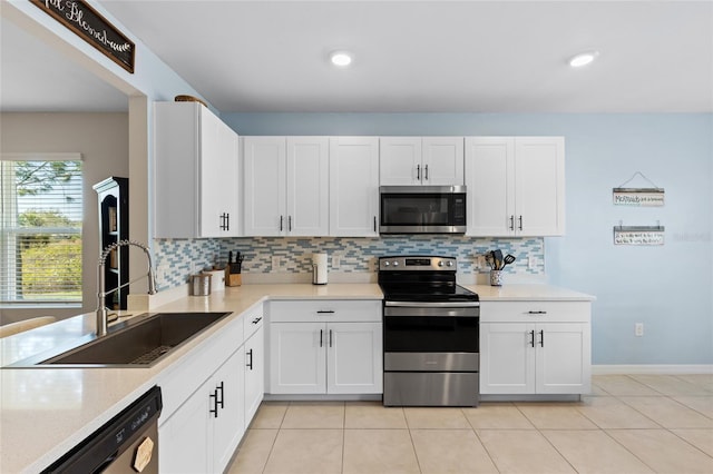 kitchen featuring light tile patterned flooring, sink, white cabinets, decorative backsplash, and stainless steel appliances