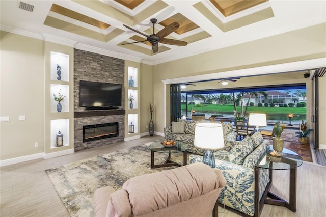 living room with ceiling fan, a stone fireplace, and ornamental molding