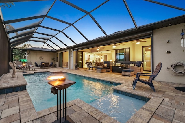 outdoor pool with glass enclosure, a patio area, and an outdoor living space with a fire pit