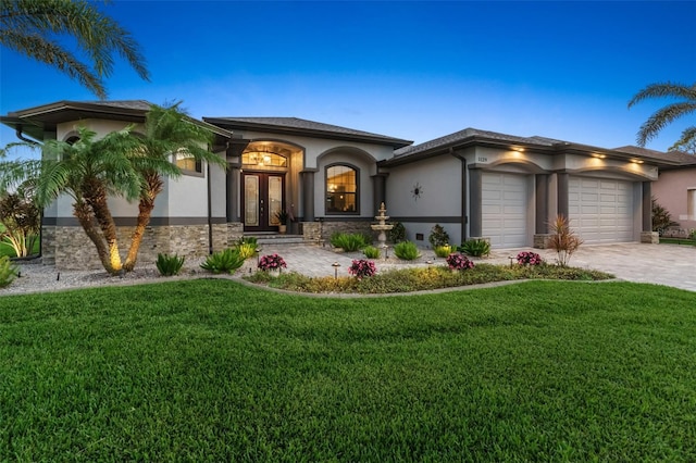 view of front facade featuring an attached garage, french doors, decorative driveway, stucco siding, and a front lawn