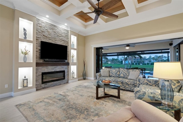 living room featuring a stone fireplace, a ceiling fan, and crown molding