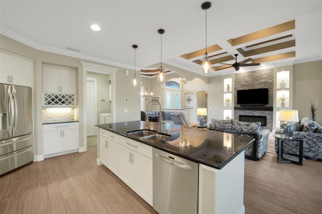 kitchen featuring white cabinetry, a kitchen island with sink, appliances with stainless steel finishes, and arched walkways