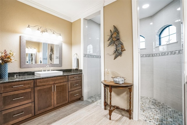 full bathroom featuring walk in shower, wood finished floors, vanity, and crown molding