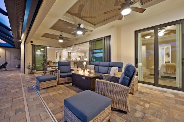 view of patio / terrace featuring a ceiling fan and an outdoor living space with a fire pit