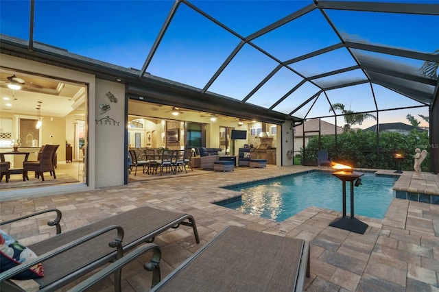 pool featuring glass enclosure, an outdoor kitchen, outdoor lounge area, and a patio area