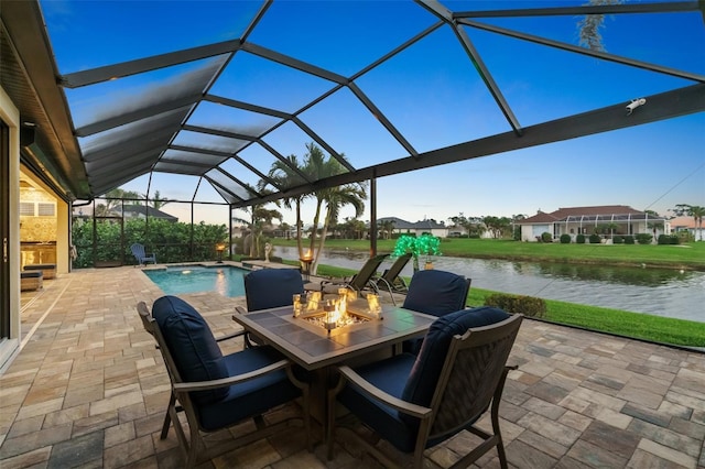 view of patio / terrace with an outdoor fire pit, an outdoor pool, glass enclosure, and a water view