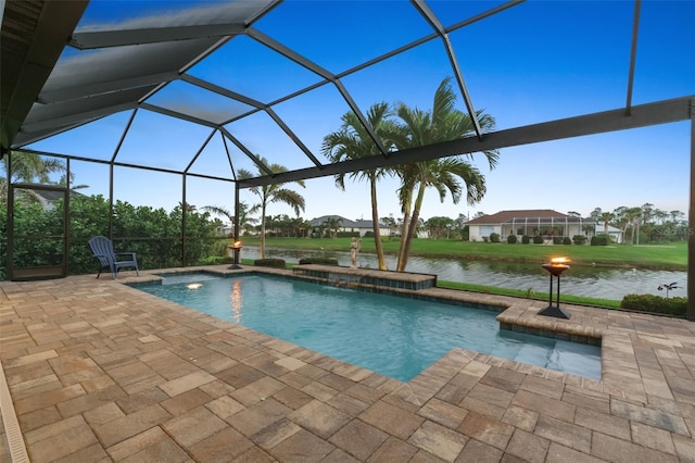 outdoor pool featuring glass enclosure, a water view, and a patio