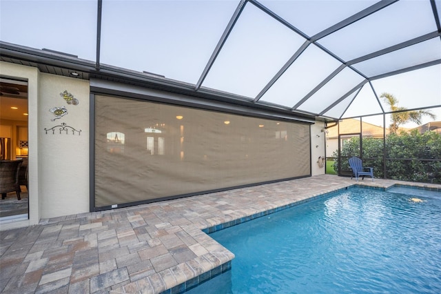 pool with glass enclosure and a patio