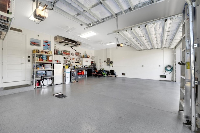 garage featuring a workshop area, electric panel, and a garage door opener