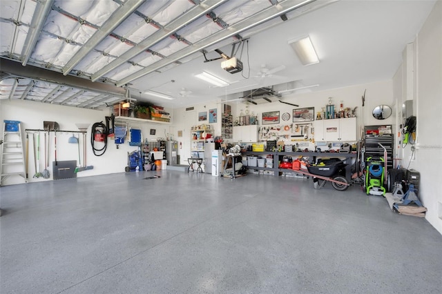 garage featuring a garage door opener, electric water heater, ceiling fan, and a workshop area