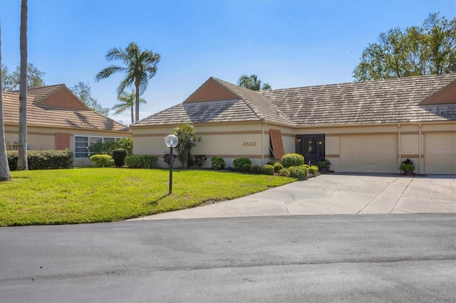 single story home featuring a garage and a front yard